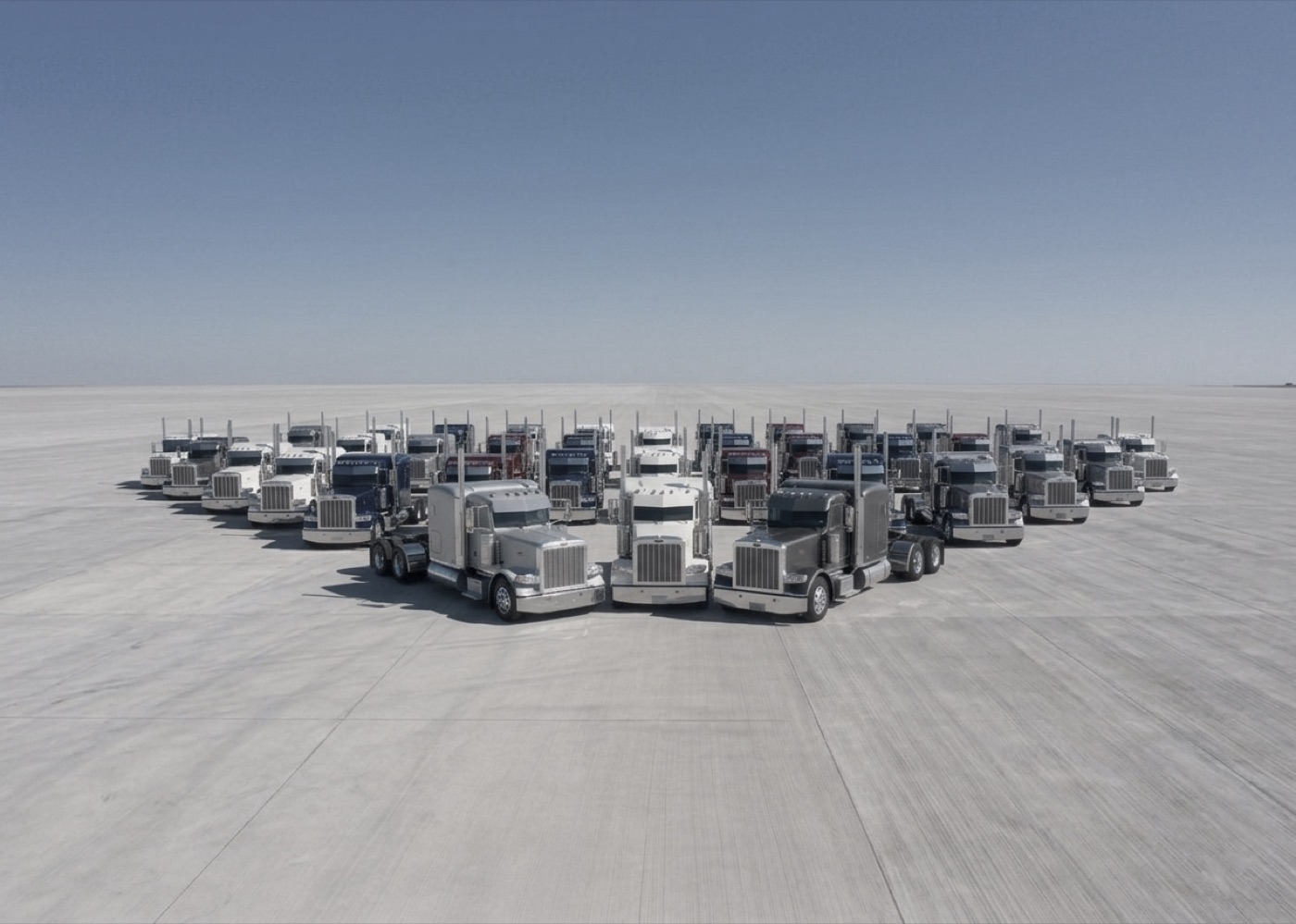 A row of semi-trucks at a fleet yard